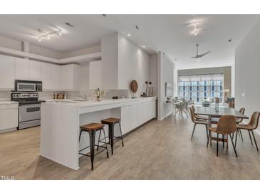 Modern kitchen featuring white cabinets, countertops, and a breakfast bar with seating at 319 Fayetteville St # 509, Raleigh, NC 27601