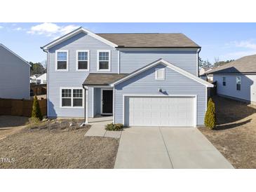 Charming two-story home features light blue siding, a two-car garage, and a well-manicured lawn at 3517 Strawberry Patch Row, Raleigh, NC 27604