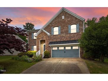 Charming brick home featuring a two-car garage, stone accents, and lush landscaping at 3614 Kilgo Dr, Durham, NC 27705