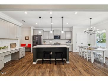 Bright, open kitchen with a large island, modern appliances, and a dining area at 3800 Cross Timber Ln, Raleigh, NC 27603