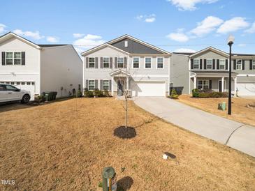 Charming two-story home with a well-manicured lawn and a two-car garage at 932 Peninsula Pl, Knightdale, NC 27545
