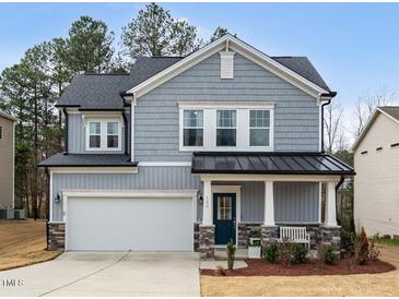 Charming two-story home featuring stone accents, a covered porch, and a well-manicured front yard at 105 Palladium Ct, Elon, NC 27244