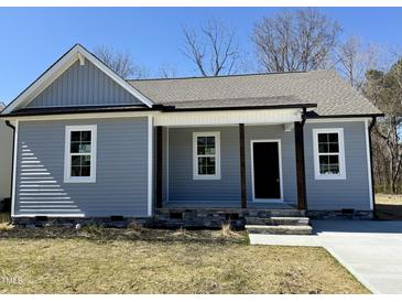 Charming single-story home with a covered porch, gray siding, and a well-manicured front yard at 119 Daniel St, Oxford, NC 27565