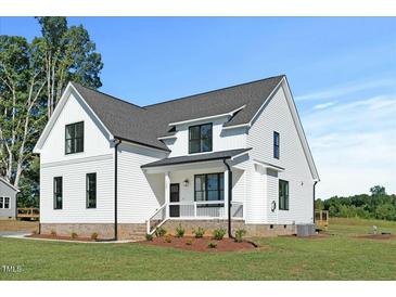 Beautiful modern farmhouse with white siding, black trim, and manicured lawn at 1467 Antioch Church Rd, Timberlake, NC 27583