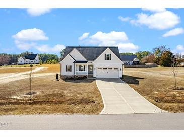 Charming two-story home featuring a long driveway, attached two-car garage, and landscaped yard at 20 Wildflower Ln, Franklinton, NC 27525