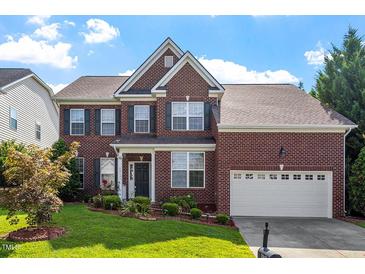 Charming two-story brick home with manicured lawn and attached two-car garage at 2017 Ollivander Dr, Cary, NC 27519