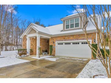 Charming home with a stone facade, complemented by a well-manicured lawn and a two-car garage during winter at 208 Abigail Ln, Gibsonville, NC 27249