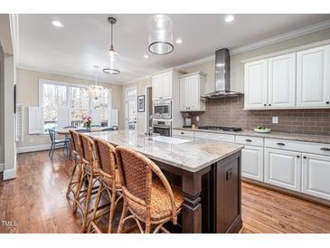 A spacious kitchen featuring a large island with seating, granite countertops, and stainless steel appliances at 260 Culbreth Rd, Chapel Hill, NC 27516