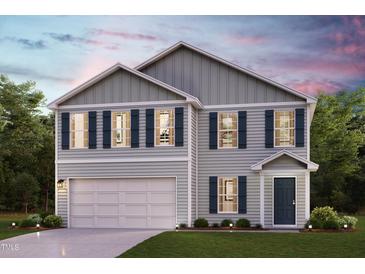 Charming two-story home with a welcoming front porch, attached two-car garage, and manicured lawn at 7576 Tanager Dr, Snow Camp, NC 27349
