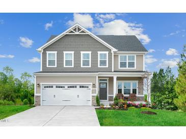 Charming two-story home featuring a two-car garage, landscaped yard, and covered front entry at 1032 Country Pasture Cv, Wendell, NC 27591