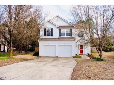 Charming two-story home featuring a well-maintained lawn, a two-car garage, and a welcoming red front door at 11 Marsh Landing Ct, Durham, NC 27703