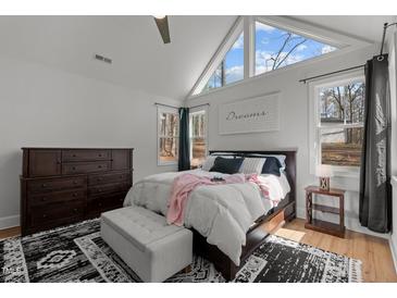 Bright main bedroom with a vaulted ceiling, large windows, a ceiling fan, and a decorative rug at 112 Rawhide Dr, Louisburg, NC 27549