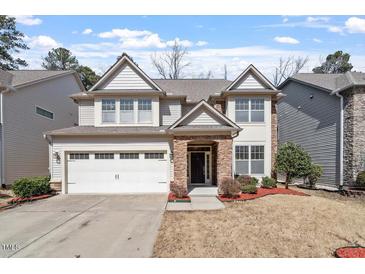Charming two-story home with a stone facade, attached garage, and well-maintained front yard at 1135 Rosepine Dr, Cary, NC 27519