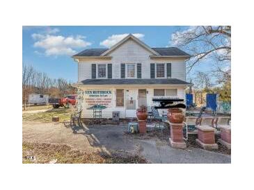 Two-story home featuring light colored siding, dark shutters, and manicured landscaping at 120 Lake Orange Rd, Hillsborough, NC 27278