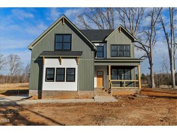 Beautiful two-story home featuring green and white siding, black framed windows, and a charming front porch at 1403 Antioch Church Rd, Timberlake, NC 27583