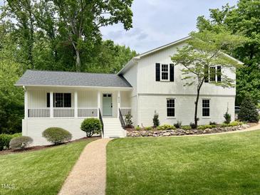 Charming white home with black shutters, manicured lawn, and inviting walkway at 2115 Port Royal Rd, Raleigh, NC 27609