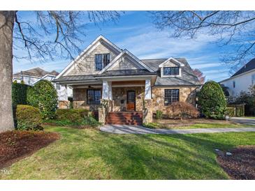 Charming stone and siding two-story home with a well-manicured front lawn and inviting curb appeal at 2920 Claremont Rd, Raleigh, NC 27608
