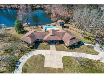 An aerial view of the stunning lakefront home with a pool and a spacious driveway at 3021 Allenby Dr, Raleigh, NC 27604