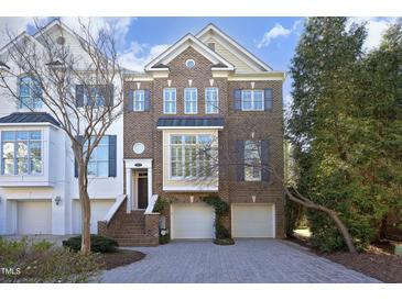 Charming brick townhome featuring a two-car garage and meticulously maintained landscaping, perfect for curb appeal at 3937 Bentley Brook Dr, Raleigh, NC 27612