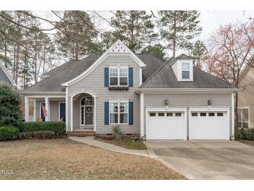Charming home featuring a manicured lawn, attached two car garage, and inviting entryway at 401 Acorn Falls Ct, Holly Springs, NC 27540