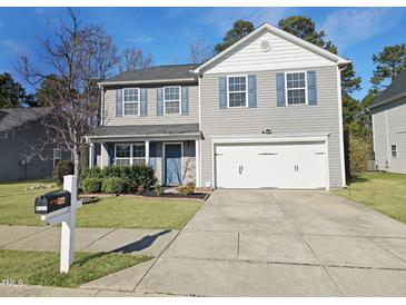 Charming two-story home with a well-maintained lawn and a two car attached garage at 5321 Carnelian Dr, Raleigh, NC 27610