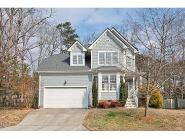 Charming two-story home with a well-maintained lawn and attached two-car garage, showcasing its classic design and curb appeal at 5806 Whispering Meadow Ln, Durham, NC 27712