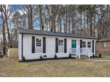Charming single-story home featuring a freshly painted exterior, black shutters, and a cheerful blue front door at 838 Waring St, Durham, NC 27704