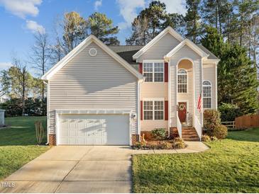 Charming two-story home featuring a well-manicured lawn and an attached two-car garage, creating a welcoming curb appeal at 1006 Scotsburg Trl, Hillsborough, NC 27278