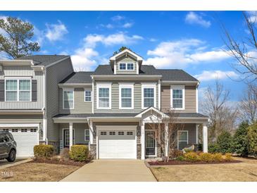Beautiful two-story home featuring a white garage door, front porch, and manicured landscaping at 110 Gulley Glen Dr, Garner, NC 27529