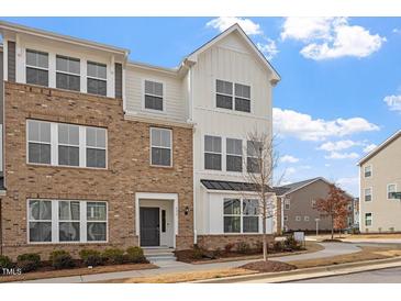 Beautiful three-story townhome with mixed brick and siding exterior, and manicured landscaping at 111 Hickory Plains Rd, Knightdale, NC 27545