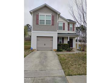 Charming two-story home featuring a covered entryway, a one car garage and classic shutters at 1141 Early Rise St, Raleigh, NC 27610