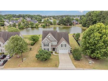 Stunning lakeside home with manicured lawn, mature trees, and a picturesque setting at 121 Stone Nut Trl, Fuquay Varina, NC 27526