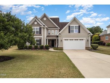 Charming two-story home featuring a manicured lawn and a spacious two-car garage at 121 Stone Nut Trl, Fuquay Varina, NC 27526