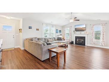 Bright living room with wood floors, fireplace, and large sectional sofa at 174 Arrow Ln, Middlesex, NC 27557
