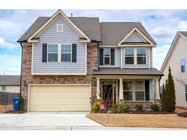 Charming two-story home featuring a stone and gray siding facade, with an attached two-car garage at 1913 Brodgen Ln, Durham, NC 27703