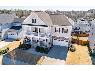 Charming two-story home with a two-car garage, a double stacked front porch, and landscaped front yard at 3418 Longleaf Estates Dr, Raleigh, NC 27616