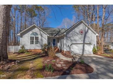 Charming one-story home featuring a well-maintained lawn, complemented by a two-car garage at 355 Riverstone Dr, Clayton, NC 27527