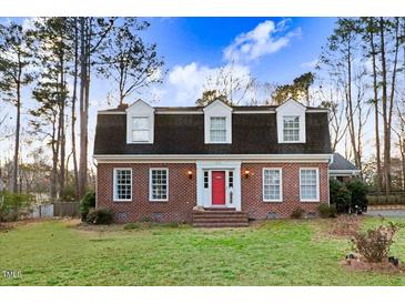 Charming brick home featuring a bright red front door and three dormer windows at 3836 Gloucester Rd, Rocky Mount, NC 27803