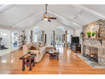 Spacious living room boasts a vaulted ceiling, hardwood floors, and a cozy fireplace at 520 Log Barn Rd, Pittsboro, NC 27312