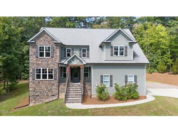 Charming two-story home with stone accents and a well-manicured lawn at 766 Horizon Dr, Pittsboro, NC 27312