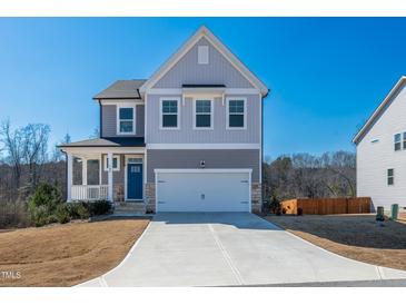 Charming two-story home with a spacious driveway and attached two-car garage at 90 Rigsby Ave, Four Oaks, NC 27524