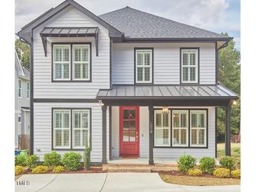 Charming two-story home with a red front door, landscaped yard, and a modern design at 1016 Addison Pl, Raleigh, NC 27610