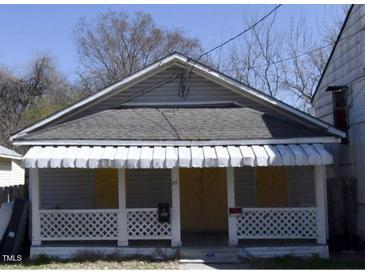 Modest single-story home with covered porch and white lattice accents on the railing at 1117 S Blount St, Raleigh, NC 27601