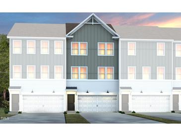 Three-story townhome showcasing charming architectural details and a two-car garage at 1410 Chrysalis Pl, Apex, NC 27502