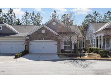 Charming home featuring a brick facade, two-car garage, and manicured landscaping at 144 Sabiston Ct, Cary, NC 27519