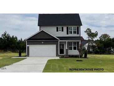 Two-story home featuring a two-car garage, gray siding, and a well-maintained lawn at 183 W Saltgrass Ln, Smithfield, NC 27577