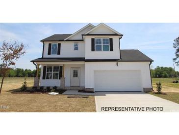 New two-story home featuring white siding, black shutters, and an attached two-car garage at 189 W Saltgrass Ln, Smithfield, NC 27577