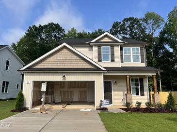 Two-story home featuring a mix of horizontal and shake siding, dark shutters, and an attached two car garage at 211 W Saltgrass Ln, Smithfield, NC 27577