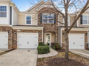 Charming townhome with stone accents, neutral siding, attached garages, and an inviting front entrance at 2459 Memory Ridge Dr, Raleigh, NC 27606