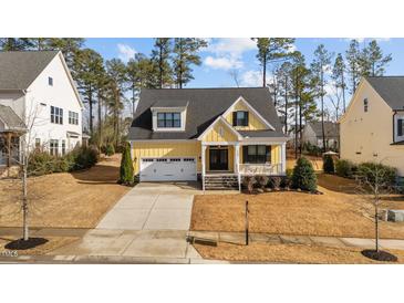 Charming yellow two-story home with a well-manicured lawn and attached two-car garage at 2500 Plowridge Rd, Fuquay Varina, NC 27526